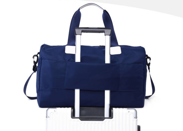 Ceļošanai piemērota tekstila soma ar emblēmu