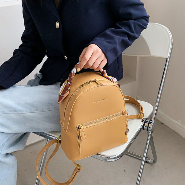 Moderna sieviešu ādas mugursoma ar metāla kulonu un šalli