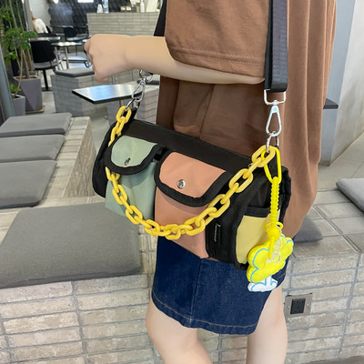 Kis gyerektáska zsebbel és vállfogantyúval