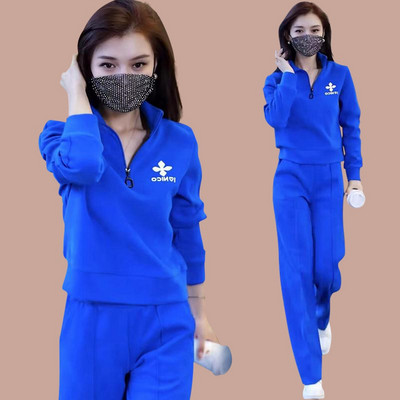 Sportisks divdaļīgs komplekts ar rāvējslēdzēja augšdaļu un izšuvumu un apakšā ar kabatu