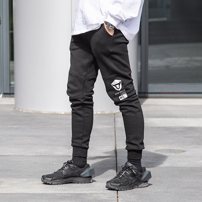 Pieguļošs vīriešu sporta bikšu modelis ar uzrakstu