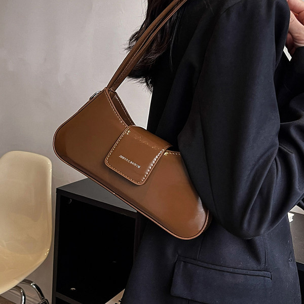 Ādas rokassomiņa ar iegravētu uzrakstu