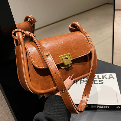 Négyzet alakú kis táska vállfogantyúval