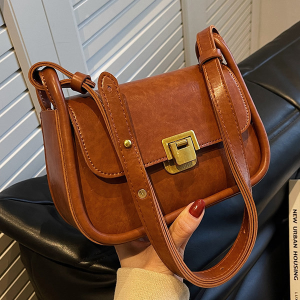 Négyzet alakú kis táska vállfogantyúval