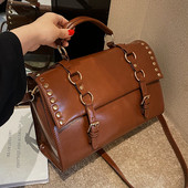 Moderna rokassomiņa ar metāla riņķiem - melnā un brūnā krāsā