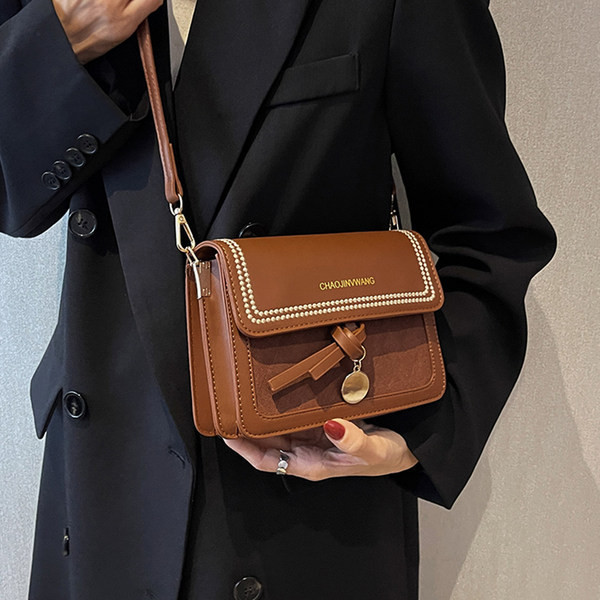 Kézitáska fém medállal és felirattal