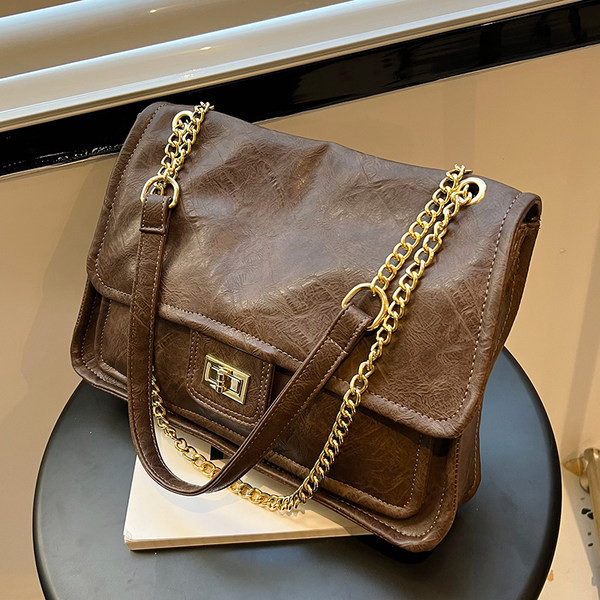 Kvadrātveida rokassomiņa ar ķēdes plecu rokturi un rāvējslēdzēja un sprādzes aizdari