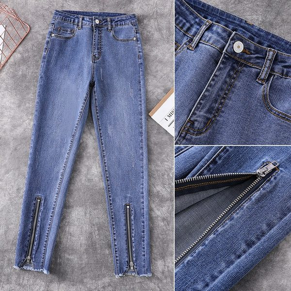 Kõrge vöökohaga naiste liibuvad teksad, mille säärtel on tõmblukk