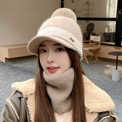 Moodne naiste müts visiiri ja pom-pomiga