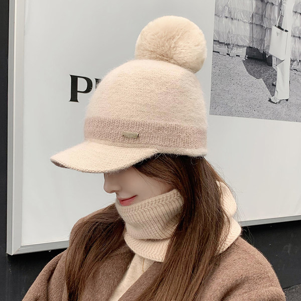 Moodne naiste müts visiiri ja pom-pomiga