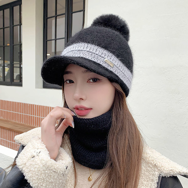 Moodne naiste müts visiiri ja pom-pomiga