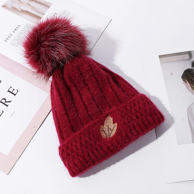 Naiste kootud müts tikandi ja pommiga