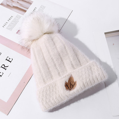 Naiste kootud müts tikandi ja pommiga