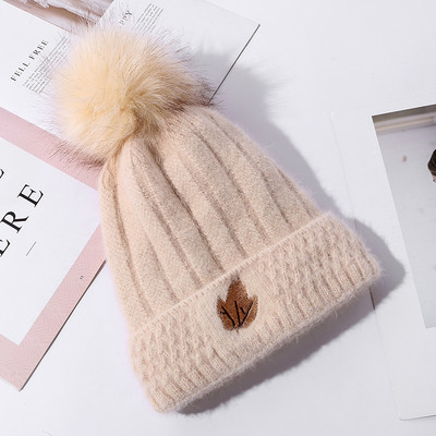 Naiste kootud müts tikandi ja pommiga