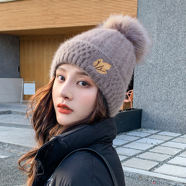 Naiste kootud müts tikandi ja pommiga