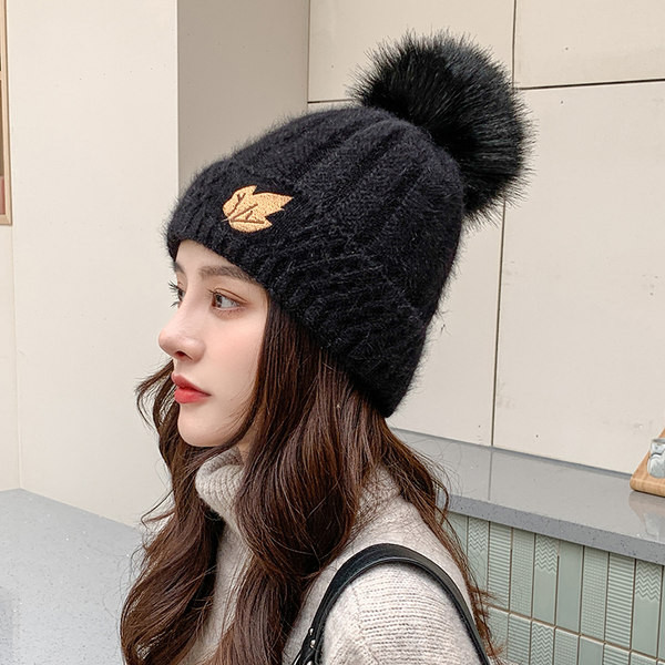 Naiste kootud müts tikandi ja pommiga