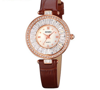 Ümara kuju ja kivikestega naiste käekell