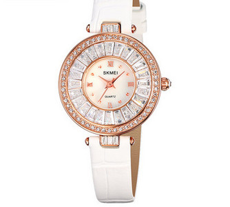 Ümara kuju ja kivikestega naiste käekell