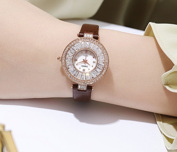 Ümara kuju ja kivikestega naiste käekell