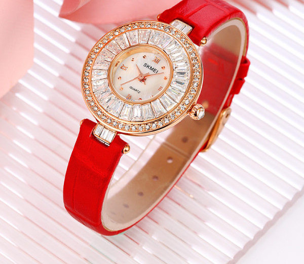 Ümara kuju ja kivikestega naiste käekell