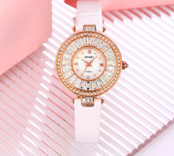 Ümara kuju ja kivikestega naiste käekell