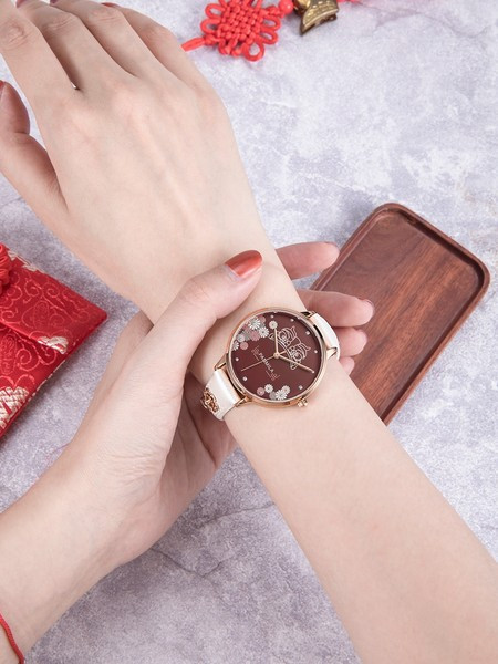 Dekoratiivsete elementide ja nahkrihmaga naiste käekell