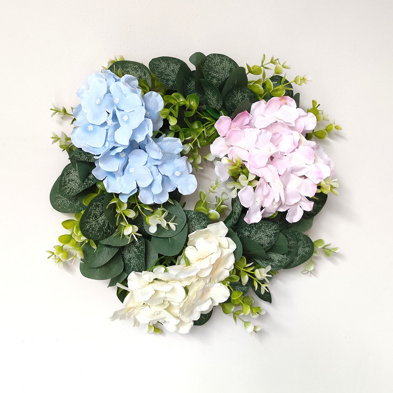 Mākslīgās rozes un mazie margrietiņu ziedi, zaļo lapu vainags eikalipta vītne mājas dekorēšanai durvju dekorēšanai