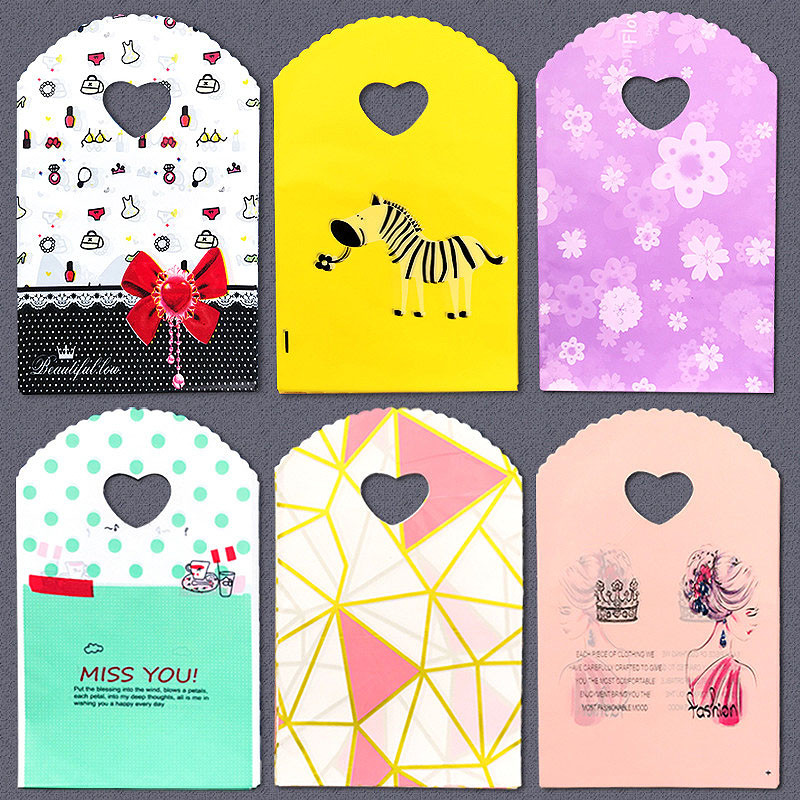 50 τμχ/παρτίδα Διάφορα μοτίβα κοσμήματα Πλαστική τσάντα σε σχήμα καρδιάς Οβάλ λαβές Μίνι τσάντα συσκευασίας δώρου Κατάστημα μικρές τσάντες αγορών