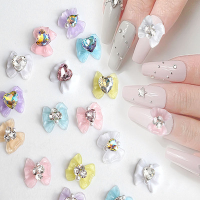 10 db Nail Art Káprázatos tervezői varázslatok műanyag gyöngykristály köröm strasszok csokornyakkendő alakú luxus körömbűvek díszek
