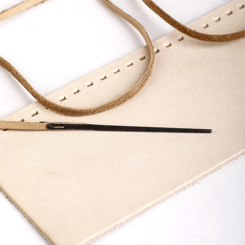 2vnt odinės siuvimo adatos, vienos ir dvigubos skylės, „pasidaryk pats“ austos odinės virvės, apsiūtos su adatomis.