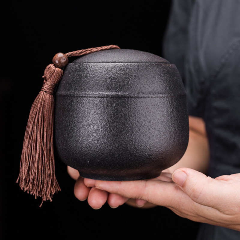 Melns keramikas zārks, rupjš piemiņas konteiners, cieši noslēgts urnas patversme kapa pelni konservēšanas burka mājdzīvnieku cilvēku piemiņas kremēšanai