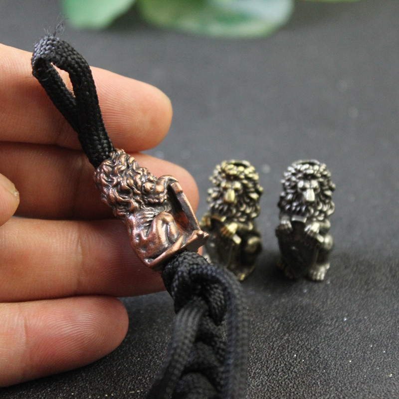 Lõvikuningat hoidev öökullikilp Kujukese messingist nuga helmed EDC õues meisterdades Paracord kootud käevõru, kaelaripatsiga ripatsiga tööriistatarvikud