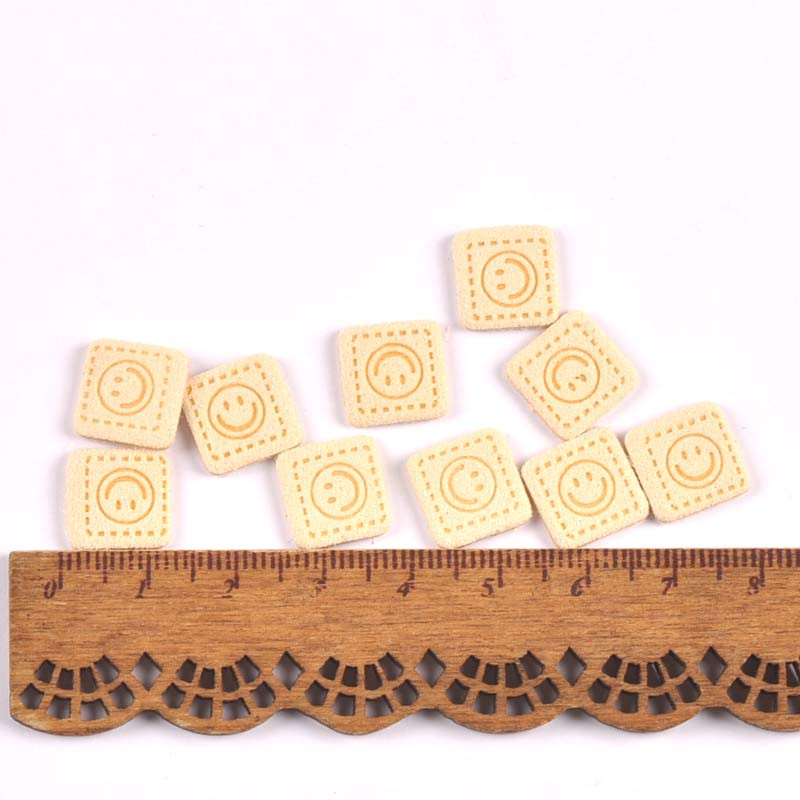 50 db Mini négyzetes mosolymintás dombornyomott címkék ruhákhoz varrás kiegészítők barkácsolás ruházati kellékek táskák kalapok címkék 11,7 mm C3529