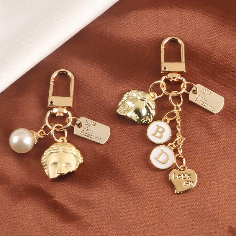 2 db táska medál Kreatív aranyos gyöngy félarcú ötvözet kulcstartó Divat autós kulcstartó kulcstartó medál táska bűbáj ékszer kiegészítők