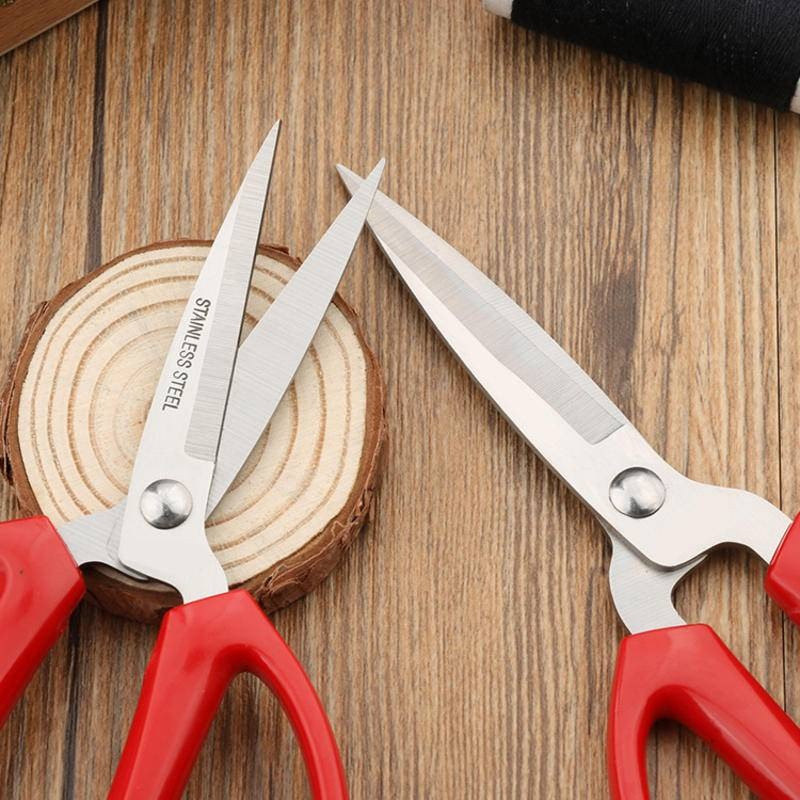 Vintage sarkana drēbju šūšana, izšuvumi šķēres, griezti audumi, nerūsējošais tērauds, smalki smaili, precīzi amatniecība, ar rokām darināti apģērbi