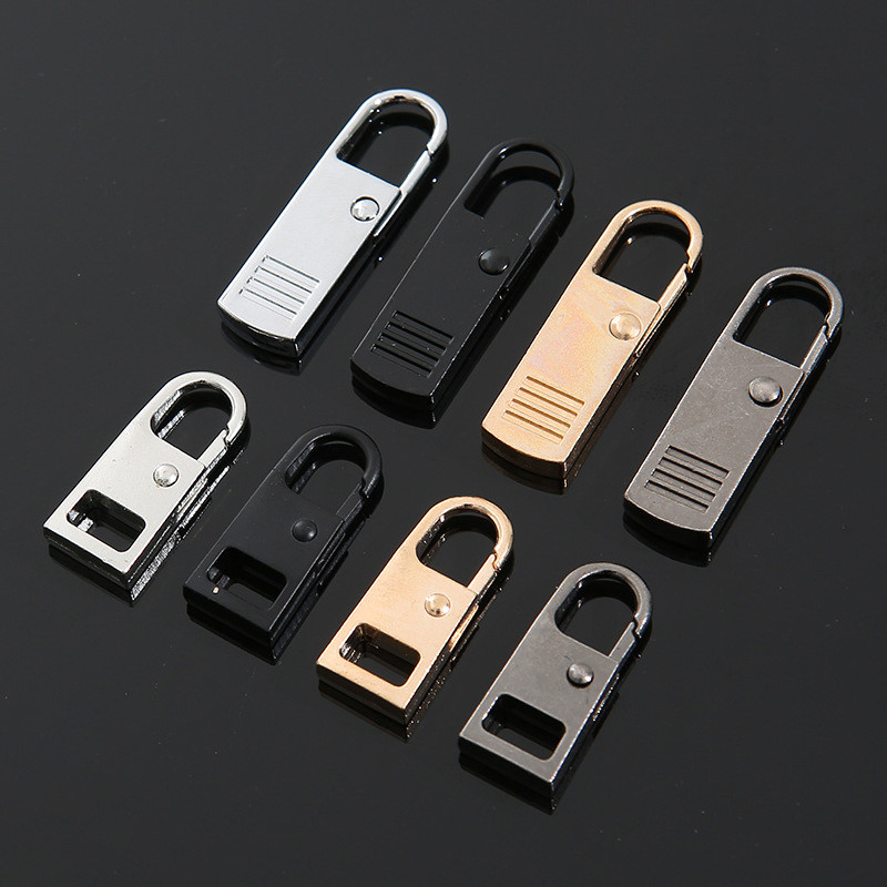 5/10 gab. Rāvējslēdzēja slīdnis Metāla rāvējslēdzēja labošanas pievilkšanas nomaiņa Noņemama rāvējslēdzēja pievilkšanas cilne, kas paredzēta šūšanai, auduma jakas rāvējslēdzēja galvai