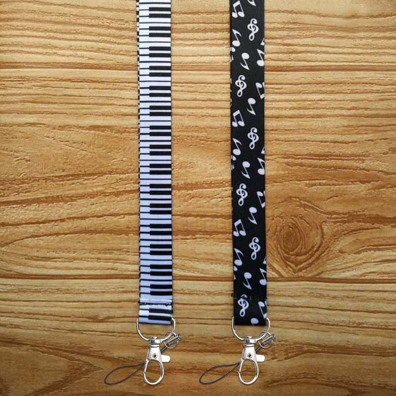 Minkšti fortepijono klavišai, patvarūs, „pasidaryk pats“ aksesuarai, rankoje laikomi pakabinami užrašai Pradžia Mobiliojo telefono dirželiai