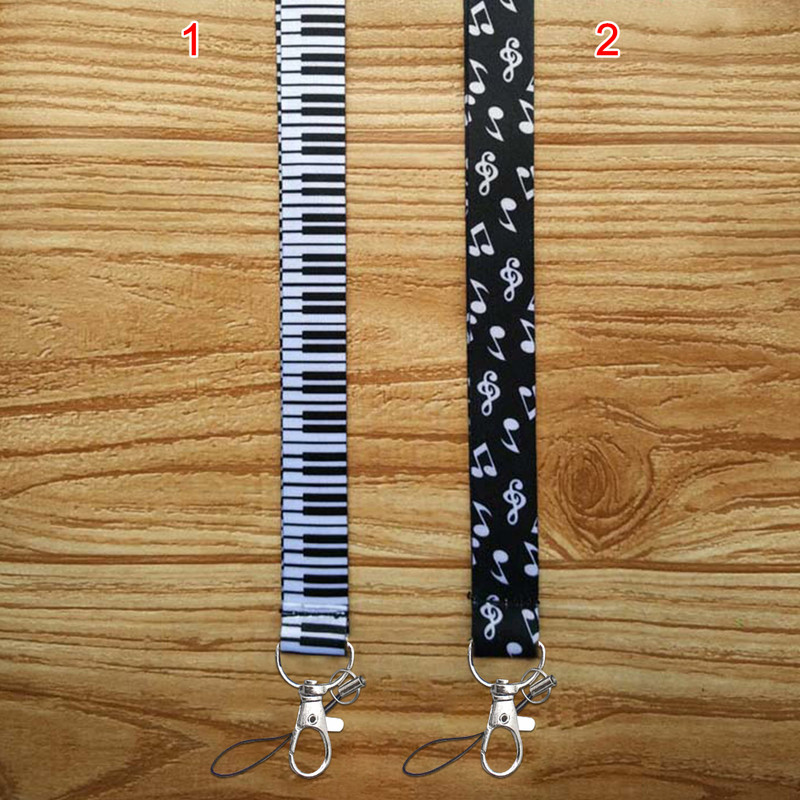 Minkšti fortepijono klavišai, patvarūs, „pasidaryk pats“ aksesuarai, rankoje laikomi pakabinami užrašai Pradžia Mobiliojo telefono dirželiai