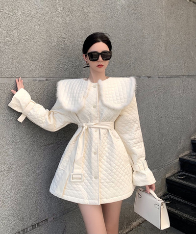 Moteriška žieminė balta striukė su kailine apykakle, viena krūtinė, vidutinio ilgio, šilti medvilniniai paminkštinti viršutiniai drabužiai, juosmens liekninamasis diržas, kratinys