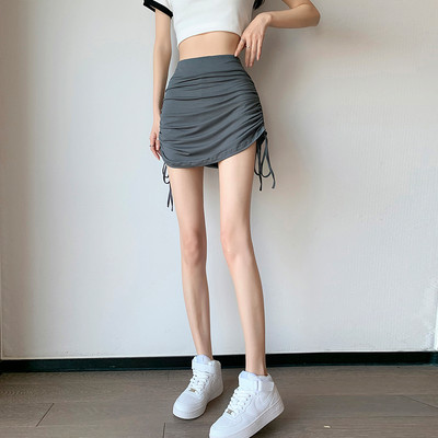 Reguliuojamas raišteliu klostuotas sėdmenų trumpas sijonas, skirtas moteriškam plonam vasariniam aukštam juosmeniui, kojų ilgiui ir plonam sijonui