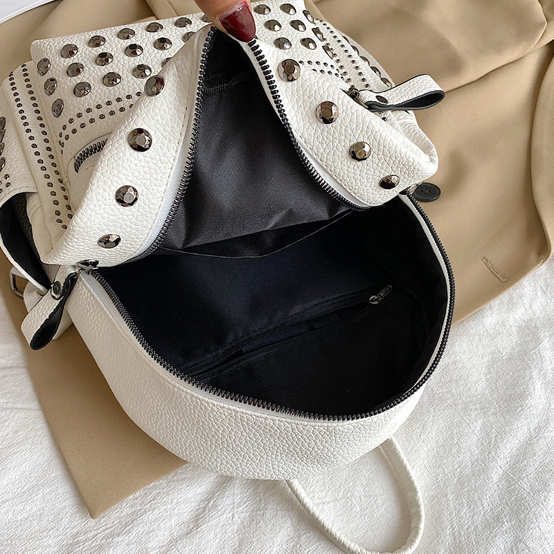 Punk-rocki stiilis neetdekooriga must naiste nahast seljakott, väike lukuga teismeliste tüdrukute kooli seljakotid naistele 2023. aasta trend