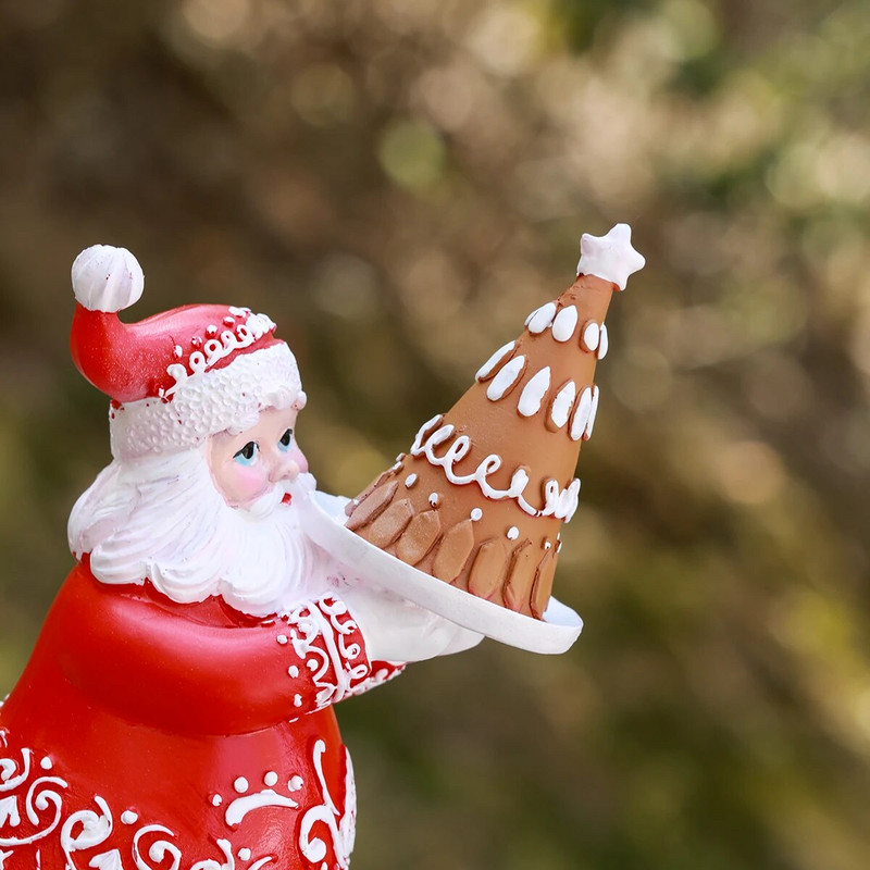 Āra dārzs Ziemassvētku burvīgs pāris, kas tur dāvanu kastītes un kūku sveķu rotājumus