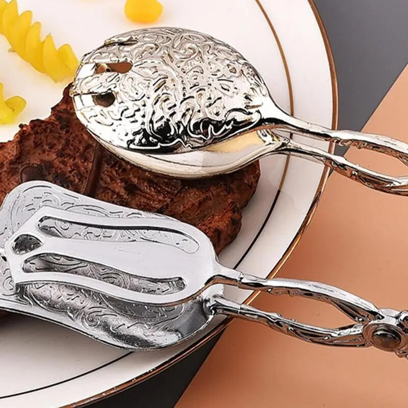 Roostevabast terasest toidutangid Toidulauanõud, mereandide serveerimisvahendid Praetud kala labidas Leivaklamber Köök majapidamises kasutatavad lihaklambrid