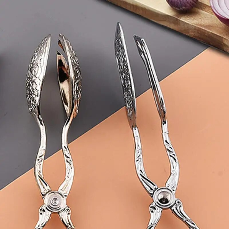 Roostevabast terasest toidutangid Toidulauanõud, mereandide serveerimisvahendid Praetud kala labidas Leivaklamber Köök majapidamises kasutatavad lihaklambrid