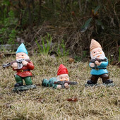 Smieklīga rūķa statuja, sveķi, kas tur rokās ieroci rūķīti, jauku figūriņu mājas darbvirsmā, amatniecības rotājumu dārzā zāliena podiņos skulptūras rotājumi