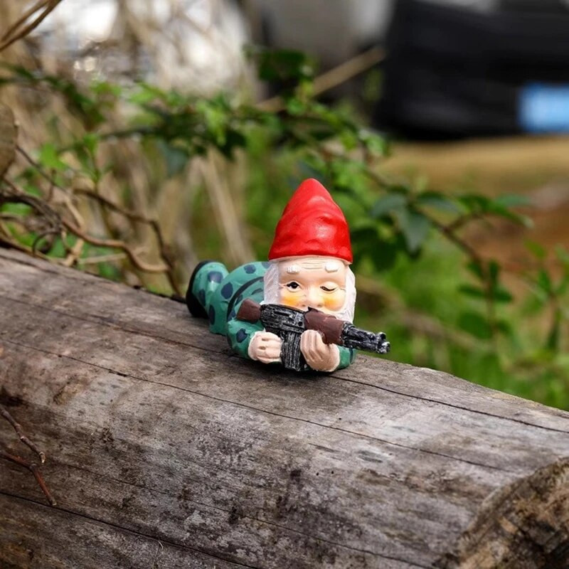 Smieklīga rūķa statuja, sveķi, kas tur rokās ieroci rūķīti, jauku figūriņu mājas darbvirsmā, amatniecības rotājumu dārzā zāliena podiņos skulptūras rotājumi