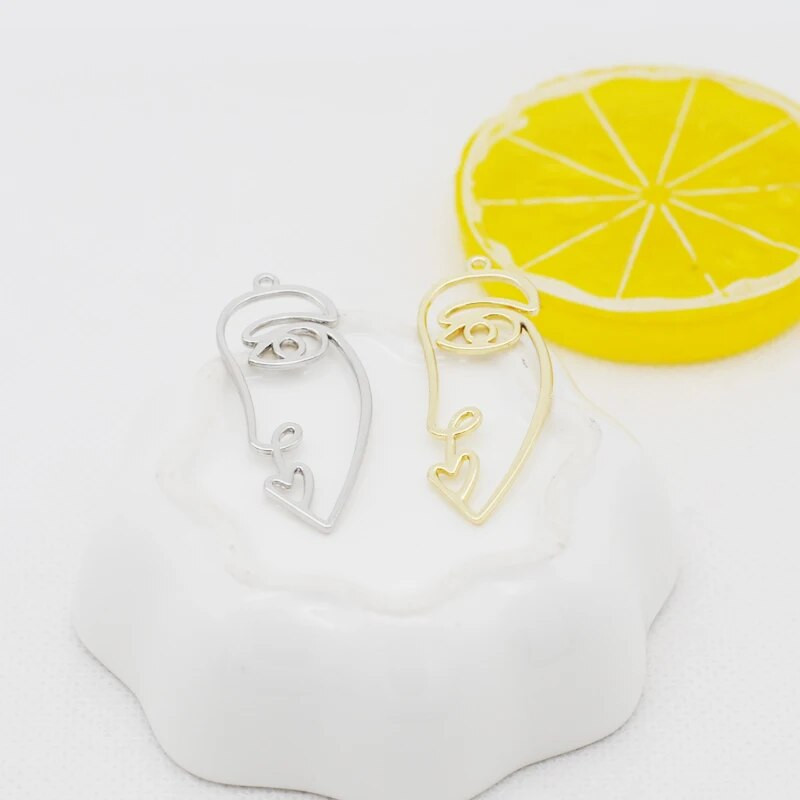 20 tk / partii uus saabumine kullavärvi õõnes abstraktne näo võlu ripatsid tsingi sulamist metallist amulettid ehete valmistamiseks 15 * 40 mm