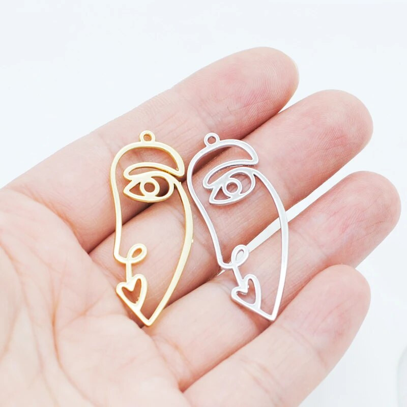 20 tk / partii uus saabumine kullavärvi õõnes abstraktne näo võlu ripatsid tsingi sulamist metallist amulettid ehete valmistamiseks 15 * 40 mm