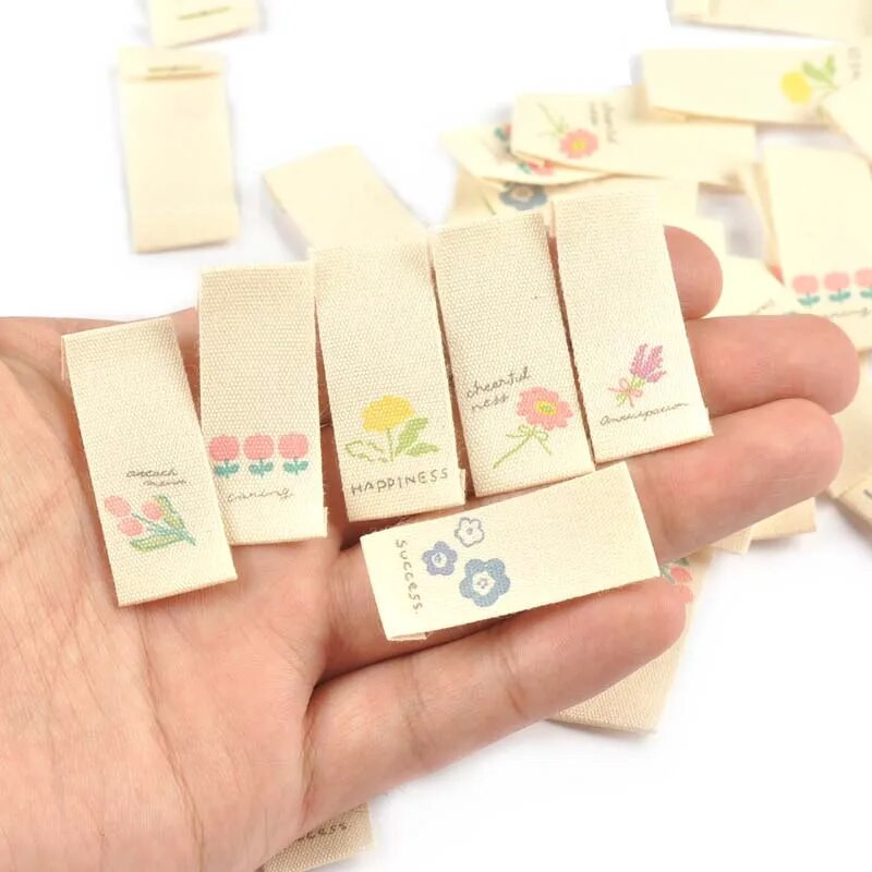 50 τμχ/παρτίδα Ετικέτες Πολύχρωμα Λουλούδια Έντυπη υφασμάτινη ετικέτα Ράψιμο Ρούχα Flag Παπούτσια Ρούχα DIY Αξεσουάρ χειροποίητων χειροτεχνιών C2887