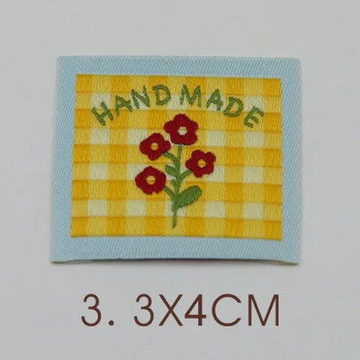 Ar rokām darināta auduma etiķete noliktavā, jauks pleds mazs zieds, kaķu izšuvumi, austa etiķete, aksesuāri, šūšana, krāsaina etiķete